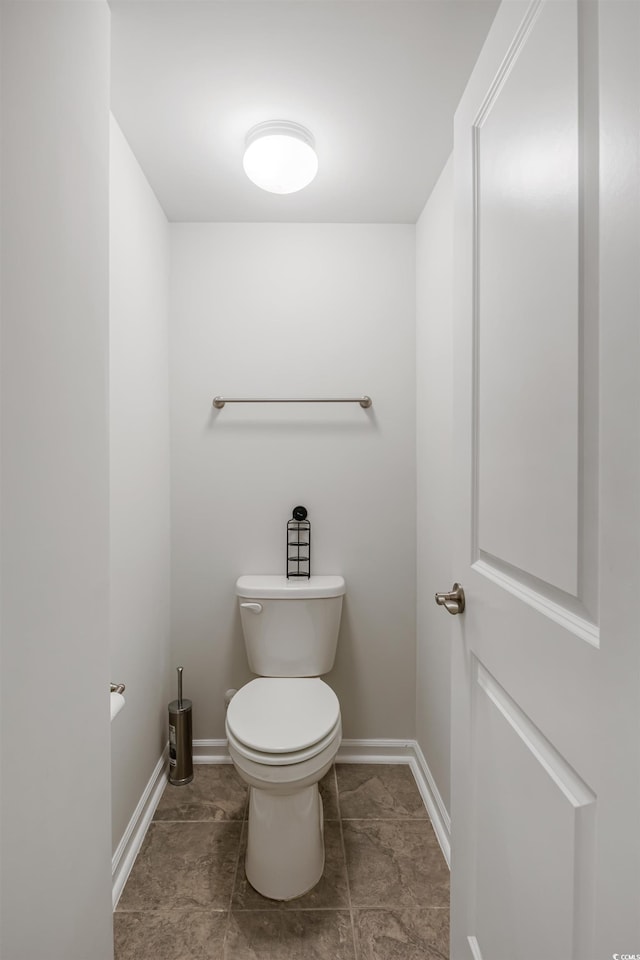 bathroom featuring baseboards and toilet