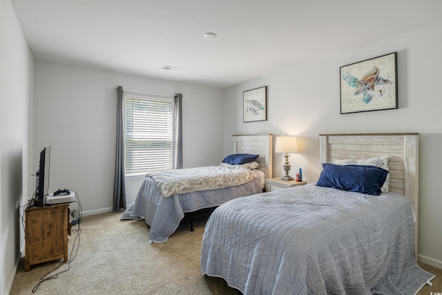 bedroom featuring light carpet, visible vents, and baseboards