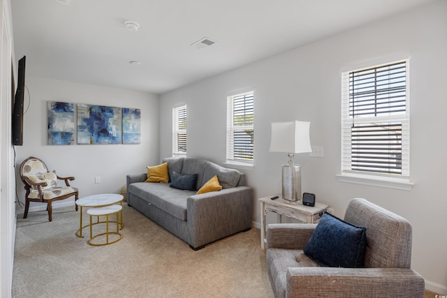 carpeted living area featuring baseboards and visible vents