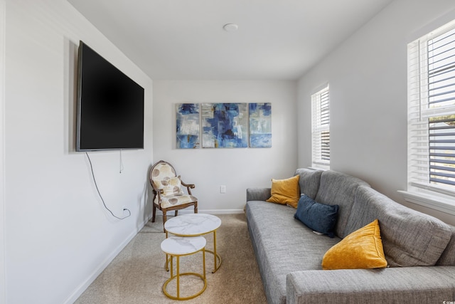 carpeted living area featuring baseboards