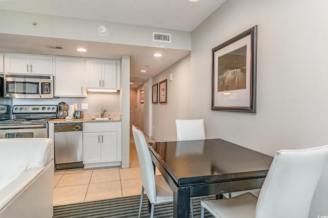 kitchen featuring appliances with stainless steel finishes, visible vents, a sink, and white cabinetry