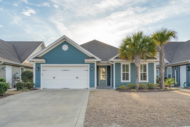 ranch-style home featuring a shingled roof, concrete driveway, and an attached garage