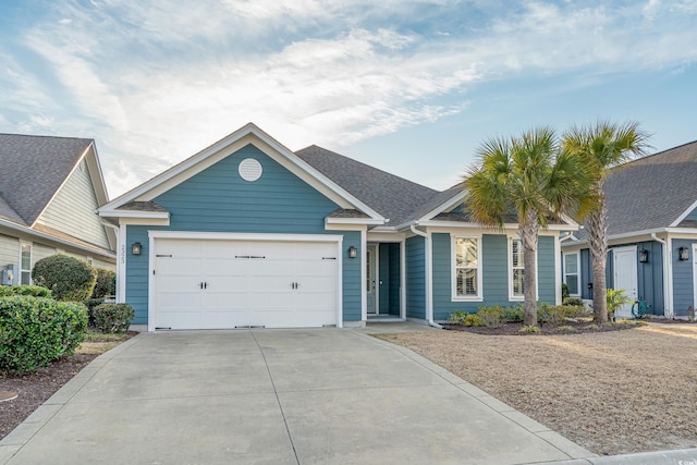 ranch-style home with a garage, driveway, and a shingled roof