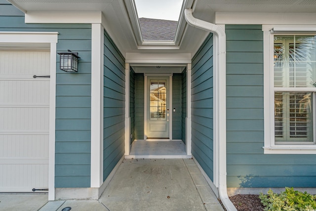 entrance to property featuring roof with shingles