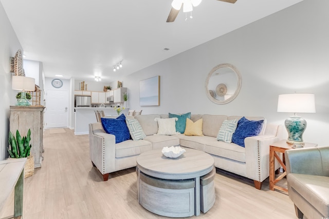 living room featuring light wood finished floors and ceiling fan