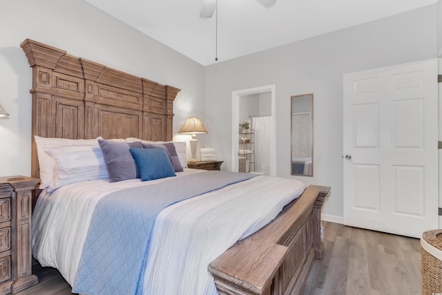 bedroom with a ceiling fan, wood finished floors, and baseboards