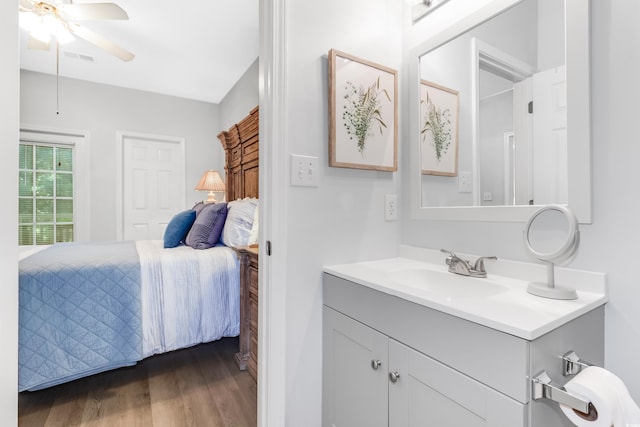 ensuite bathroom with visible vents, wood finished floors, connected bathroom, ceiling fan, and vanity