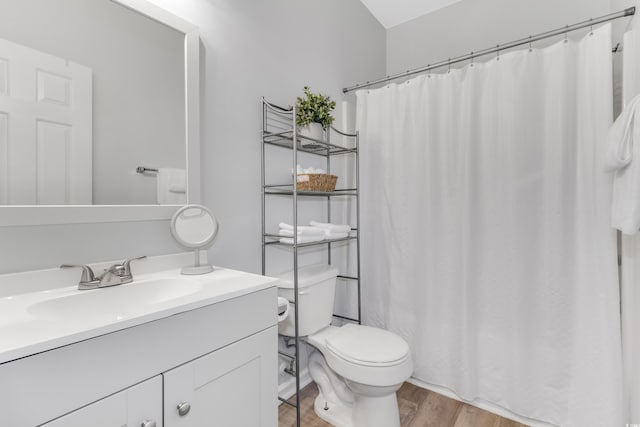 bathroom featuring vanity, a shower with shower curtain, toilet, and wood finished floors