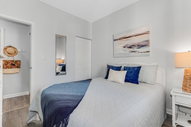 bedroom featuring a closet, baseboards, and wood finished floors