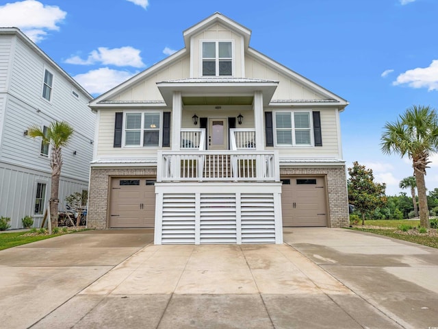 raised beach house with a garage, driveway, brick siding, and board and batten siding