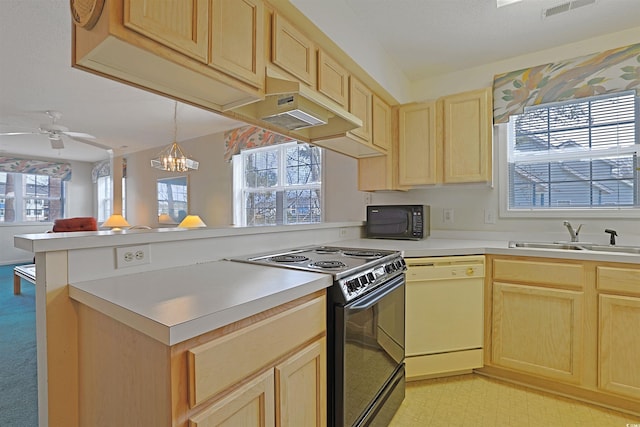 kitchen featuring a sink, black appliances, a peninsula, and light brown cabinets