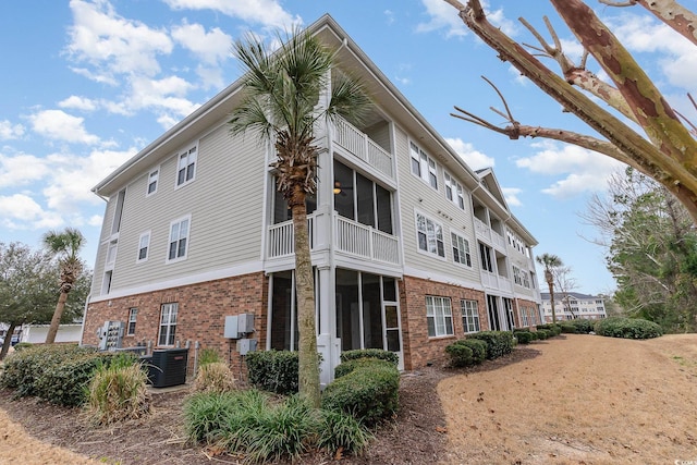 5801 Oyster Catcher Dr Unit 724, North Myrtle Beach, SC 29582 - view of home's exterior with brick siding, a sunroom, a balcony, and central AC