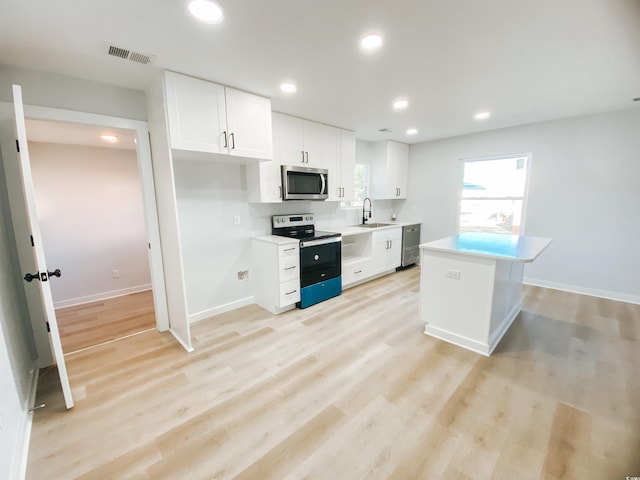 kitchen featuring white cabinets, visible vents, stainless steel appliances, and a sink