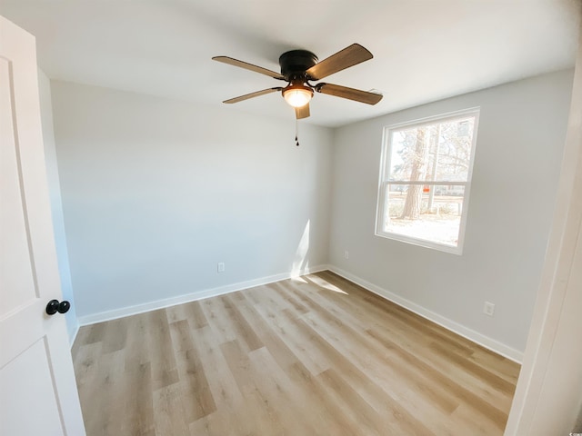 spare room with light wood-type flooring, baseboards, and ceiling fan