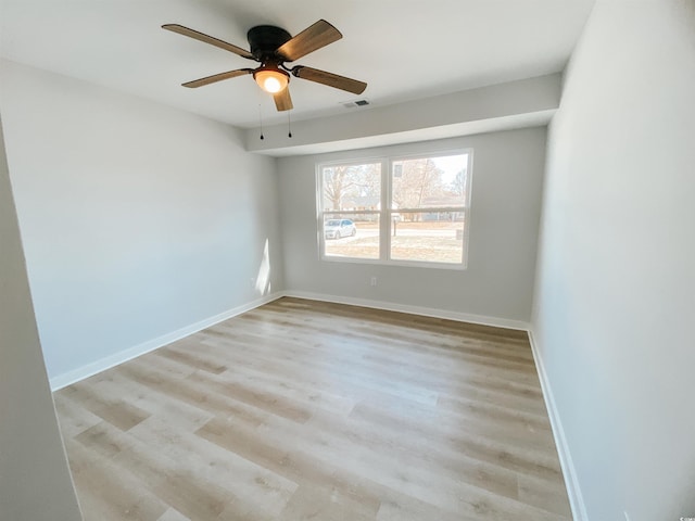 spare room with light wood-type flooring, baseboards, visible vents, and ceiling fan
