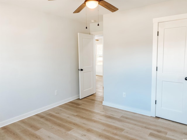 unfurnished bedroom featuring light wood-type flooring, a ceiling fan, and baseboards