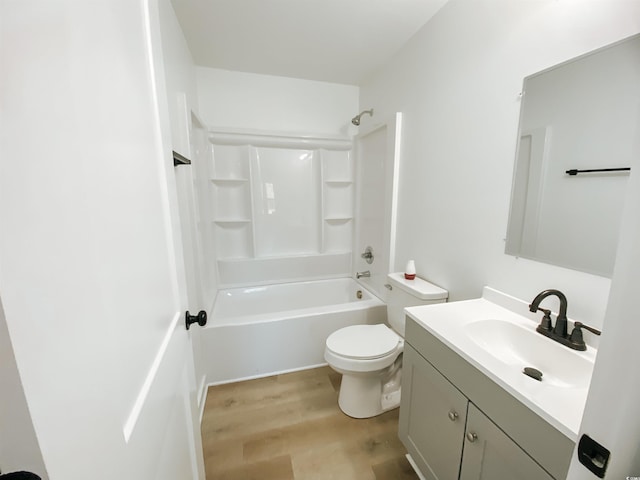 full bath with wood finished floors, vanity, washtub / shower combination, and toilet
