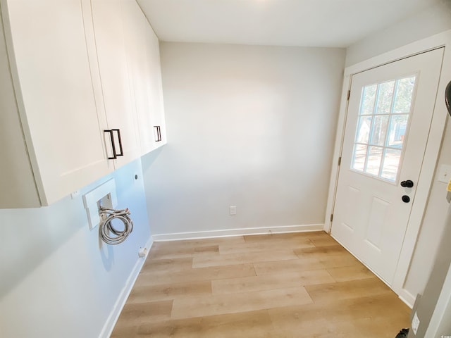 washroom featuring light wood finished floors, baseboards, hookup for a washing machine, cabinet space, and electric dryer hookup
