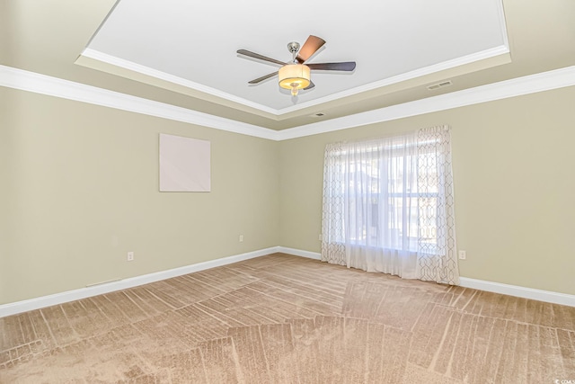 carpeted empty room featuring baseboards, visible vents, ceiling fan, ornamental molding, and a tray ceiling