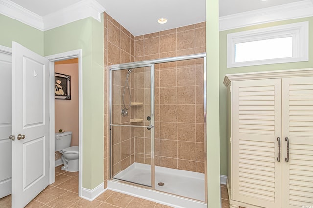 bathroom featuring toilet, a stall shower, tile patterned flooring, and ornamental molding