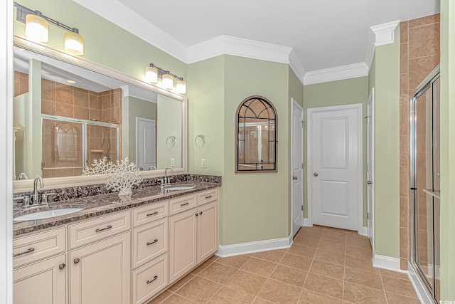 full bathroom featuring a stall shower, crown molding, tile patterned flooring, baseboards, and double vanity