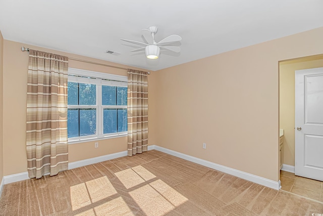 carpeted empty room featuring a ceiling fan and baseboards