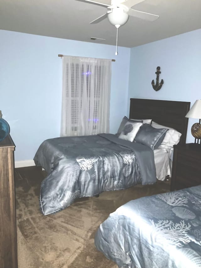carpeted bedroom featuring a ceiling fan and baseboards