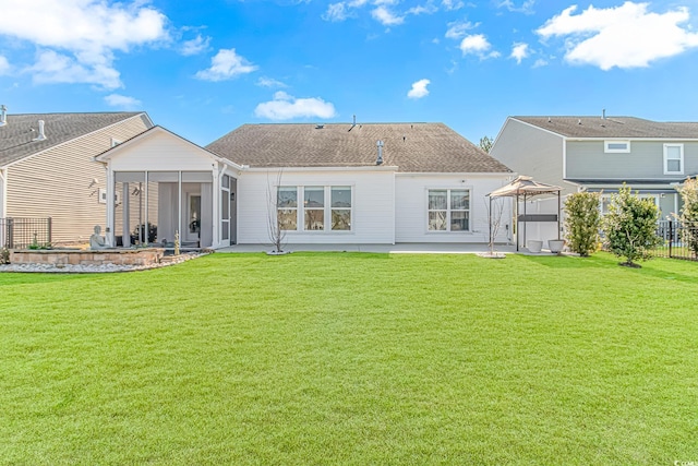 rear view of property featuring a patio area, a lawn, a sunroom, and a gazebo