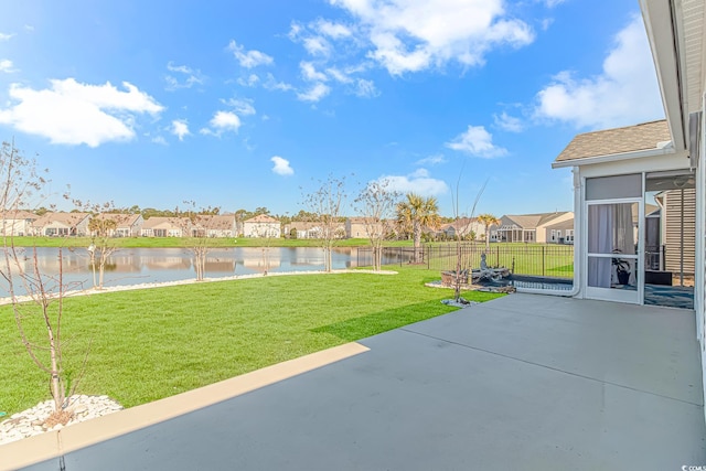 view of yard featuring a residential view, a water view, and a patio area