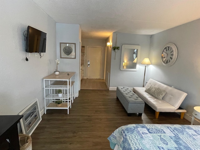 living area featuring a textured ceiling, wood finished floors, and baseboards