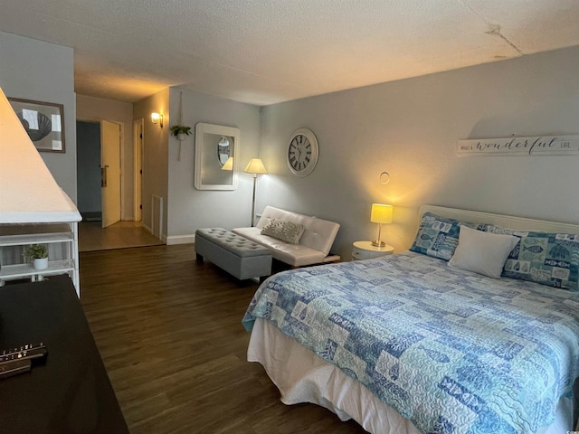 bedroom with a textured ceiling and wood finished floors