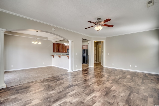 unfurnished living room featuring decorative columns, a textured ceiling, wood finished floors, and ceiling fan with notable chandelier