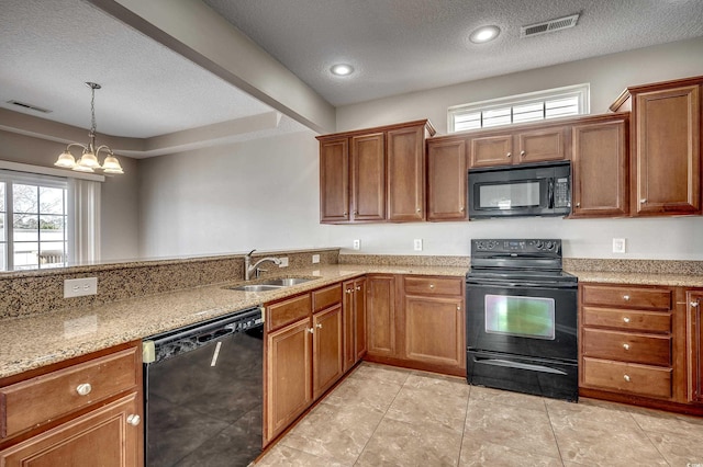 kitchen featuring a sink, visible vents, black appliances, and brown cabinetry