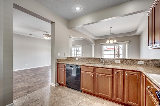 kitchen with light stone counters, a textured ceiling, black dishwasher, and a sink