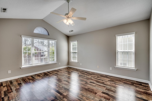 spare room featuring dark wood finished floors, visible vents, baseboards, and ceiling fan