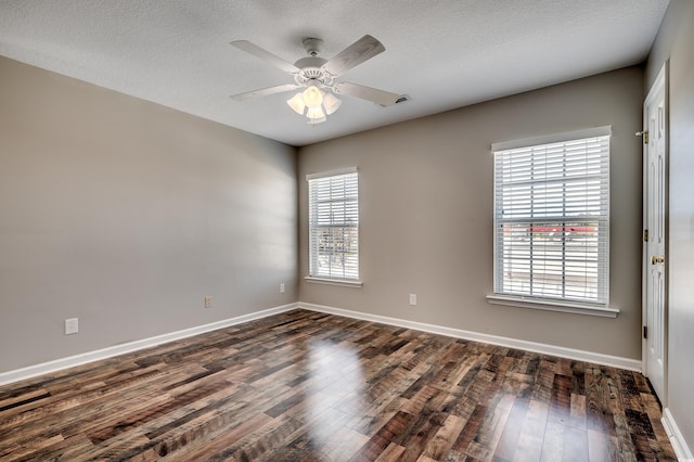 unfurnished room featuring visible vents, baseboards, and dark wood-style floors