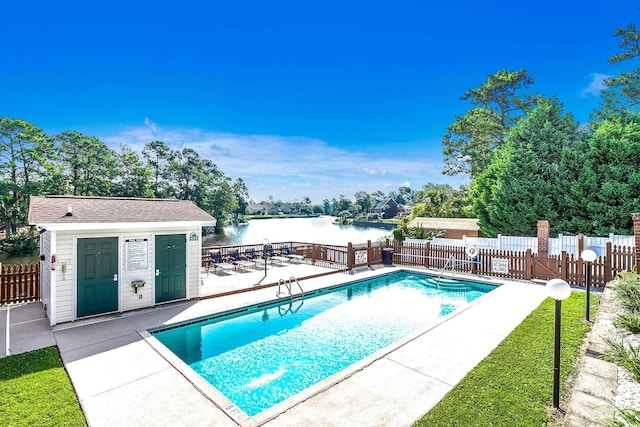 community pool featuring a patio area, a water view, and fence