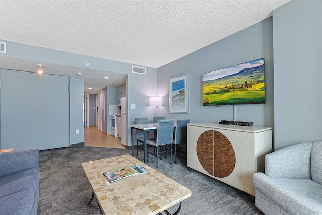 living room with a textured ceiling, visible vents, and recessed lighting