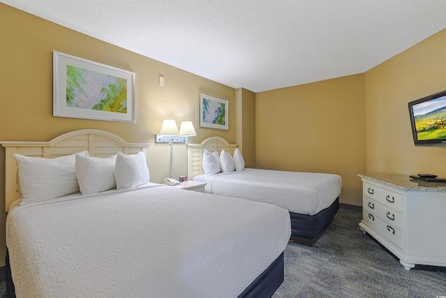 bedroom with dark colored carpet and a textured ceiling