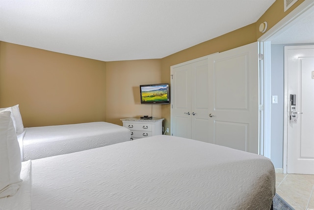 bedroom with a closet, visible vents, and light tile patterned floors