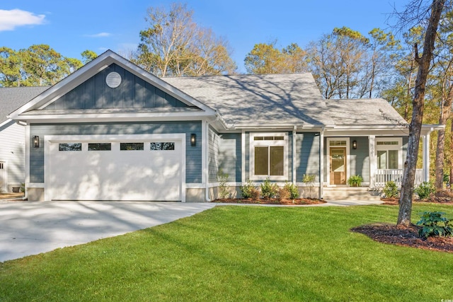 view of front of house with covered porch, an attached garage, driveway, and a front lawn