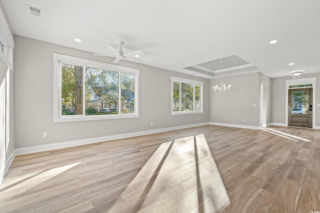 unfurnished living room featuring light wood finished floors, recessed lighting, a raised ceiling, visible vents, and baseboards