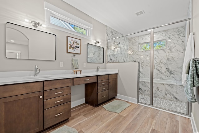 bathroom with double vanity, a sink, visible vents, and a healthy amount of sunlight