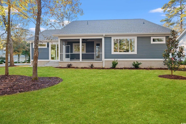 back of property featuring a yard, a shingled roof, and a sunroom