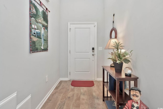 doorway featuring light wood-type flooring and baseboards