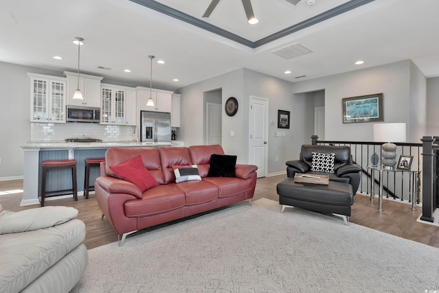 living area featuring baseboards, wood finished floors, and recessed lighting