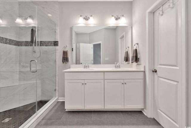 bathroom with double vanity, a stall shower, a sink, and tile patterned floors