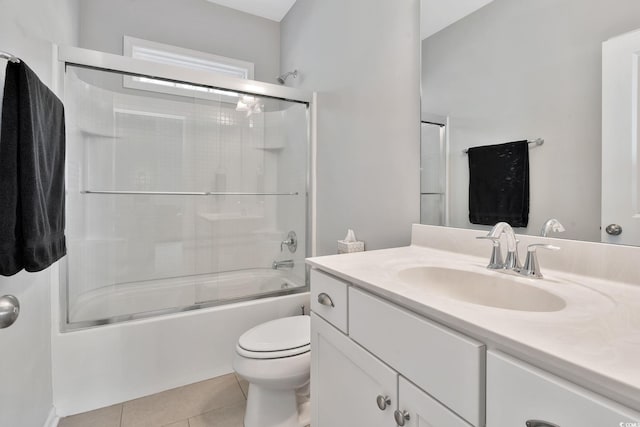 bathroom featuring tile patterned flooring, vanity, toilet, and bath / shower combo with glass door