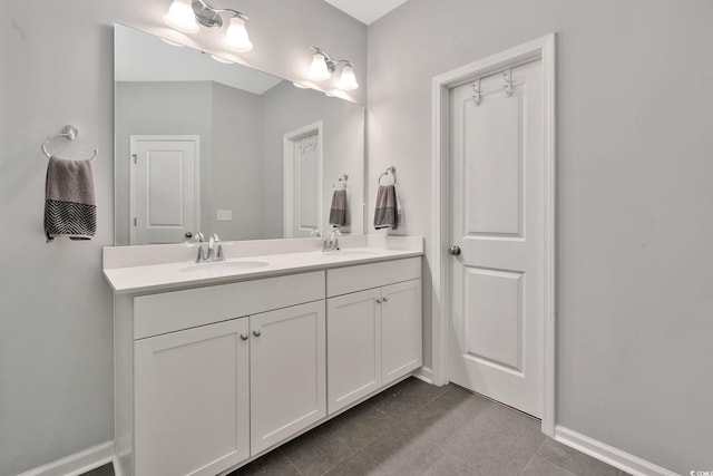 full bathroom with tile patterned floors, a sink, baseboards, and double vanity