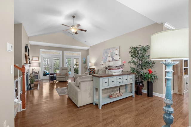 living area featuring a ceiling fan, lofted ceiling, french doors, and wood finished floors